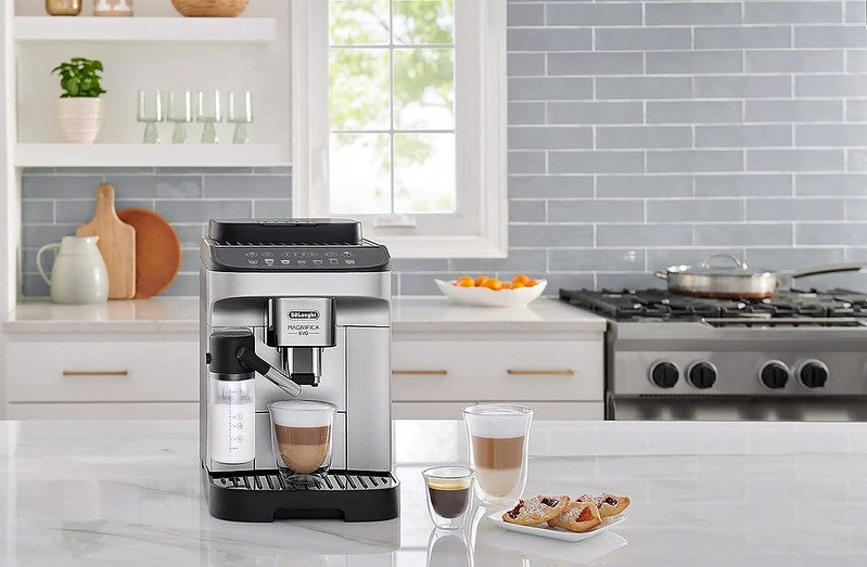 Máquina de café DeLonghi ECAM29084SB sobre mesón con dos cappuccinos servidos en cocina clara