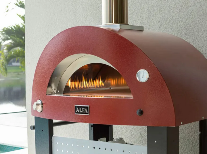 Horno de pizza exterior Alfa Forni rojo encendido con fuego visible en el interior