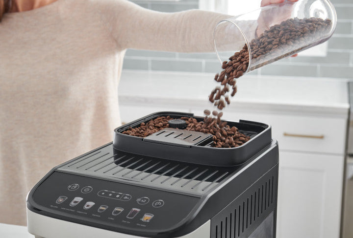 Cargando granos de café enteros en la tolva de la DeLonghi Magnifica Evo ECAM29084SB con molino integrado