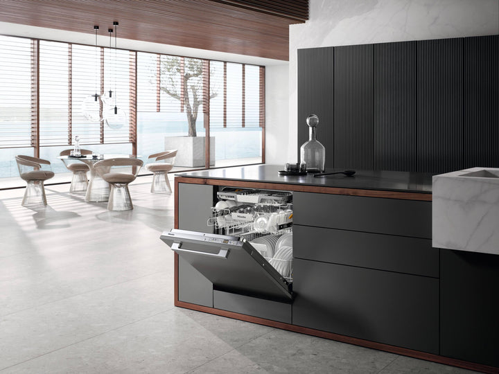Lavavajillas Miele G 5266 SCVi integrado en isla oscura de cocina de lujo con puerta entreabierta y vista al mar