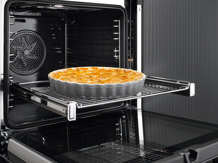Interior del horno Miele H 7660 con tarta dorada sobre la rejilla y ventilador de convección al fondo
