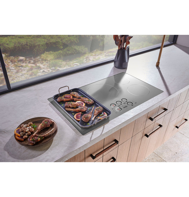 Monogram ZHU36RSTSS — cubierta de inducción de 36" en ambiente de cocina, dorando costillas de cordero sobre plancha de acero inoxidable