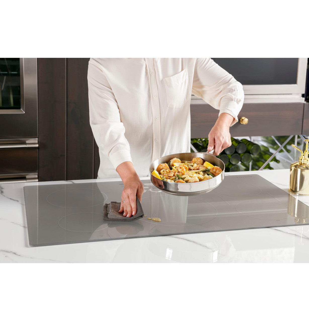 Monogram ZHU36RSTSS — superficie de vidrio liso de inducción que permanece fría al tacto, fácil de limpiar mientras se cocina en un sartén